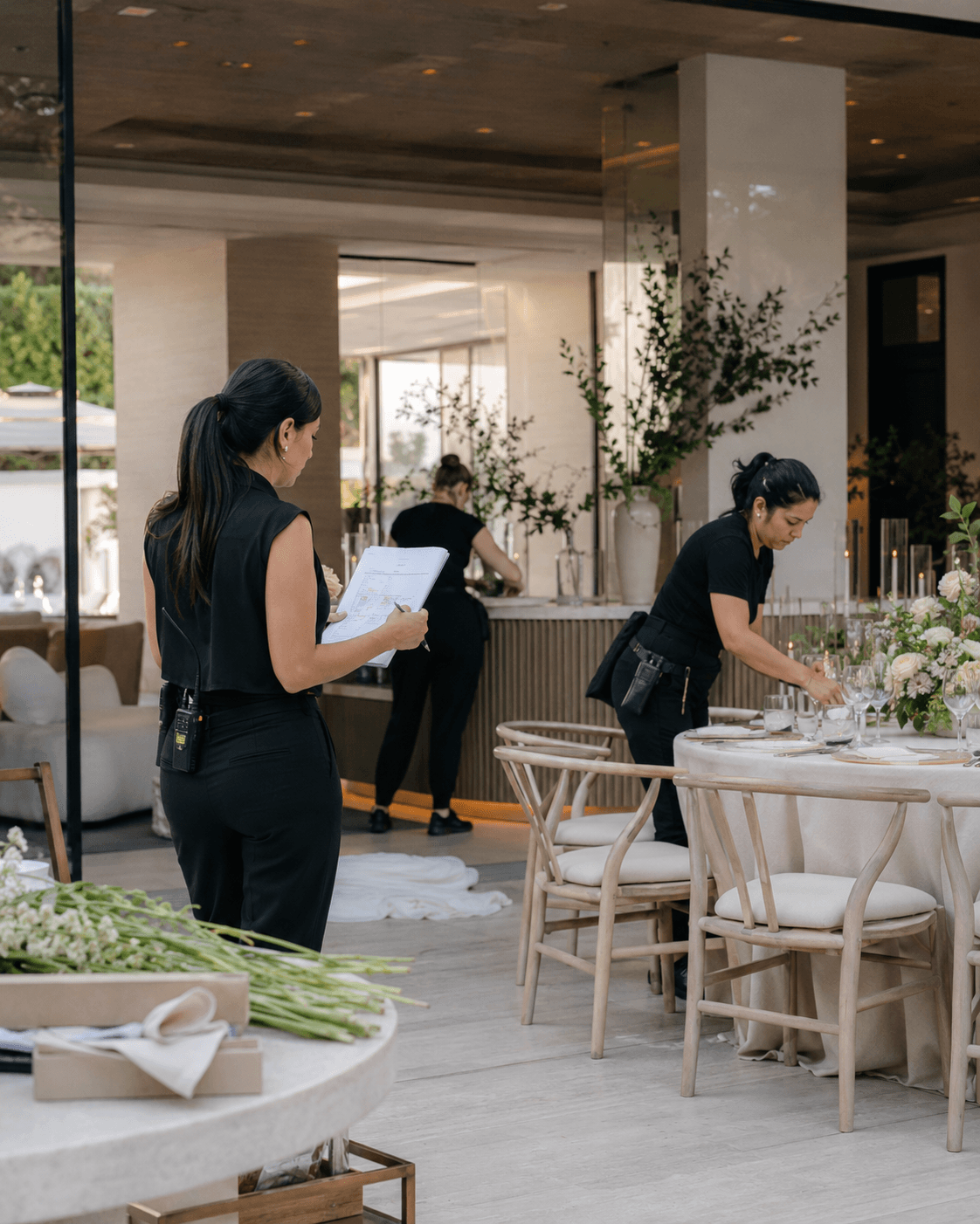 MAREA event coordinator with a run sheet and radio, staff setting the table — live production and coordination